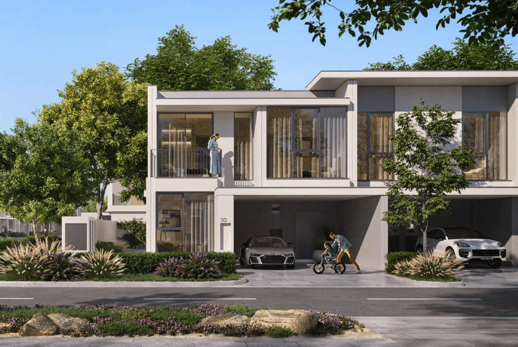 A modern townhouse exterior at Vindera at The Valley featuring large windows, private parking, landscaped greenery, and residents enjoying the outdoor space.