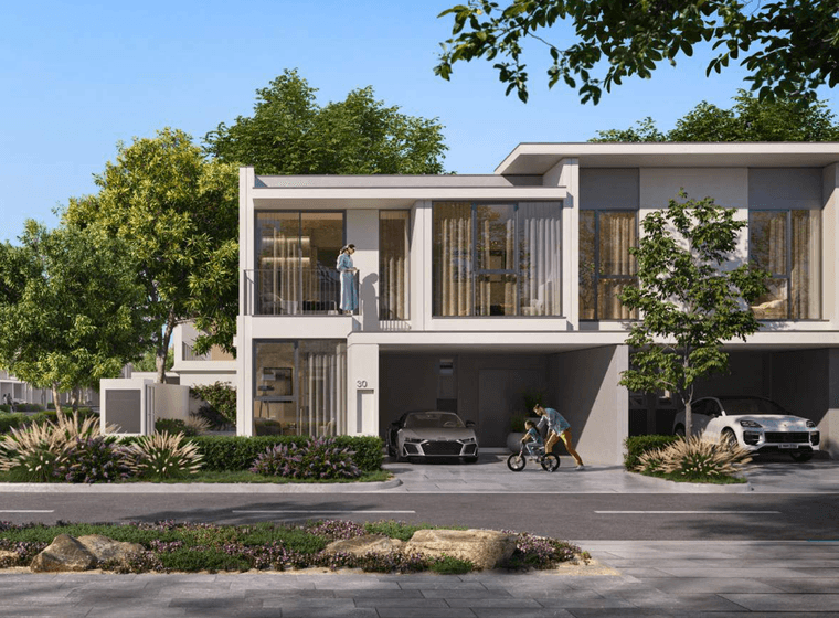 A modern townhouse exterior at Vindera at The Valley featuring large windows, private parking, landscaped greenery, and residents enjoying the outdoor space.