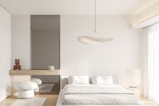 Minimalist neutral bedroom with low platform bed, soft white linens, sculptural pendant light, wood console, mushroom stools and sheer curtains.