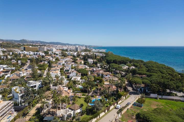 Aerial view of the Golden Mile showing villas and flats surrounded by green plants next to the blue sea