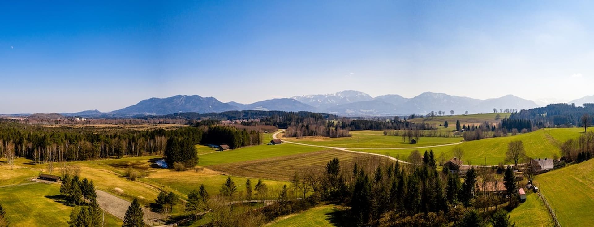Expansive aerial view of Penzberg in Bavaria, Germany, with Alpine panorama, forests and meadows – a scenic place for residential living