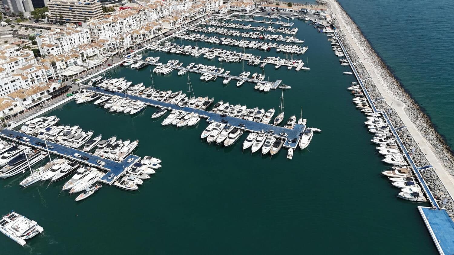 Puerto Banús mit vielen Luxusbooten, die im Hafen liegen, neben der Promenade mit luxuriösen Lokalen