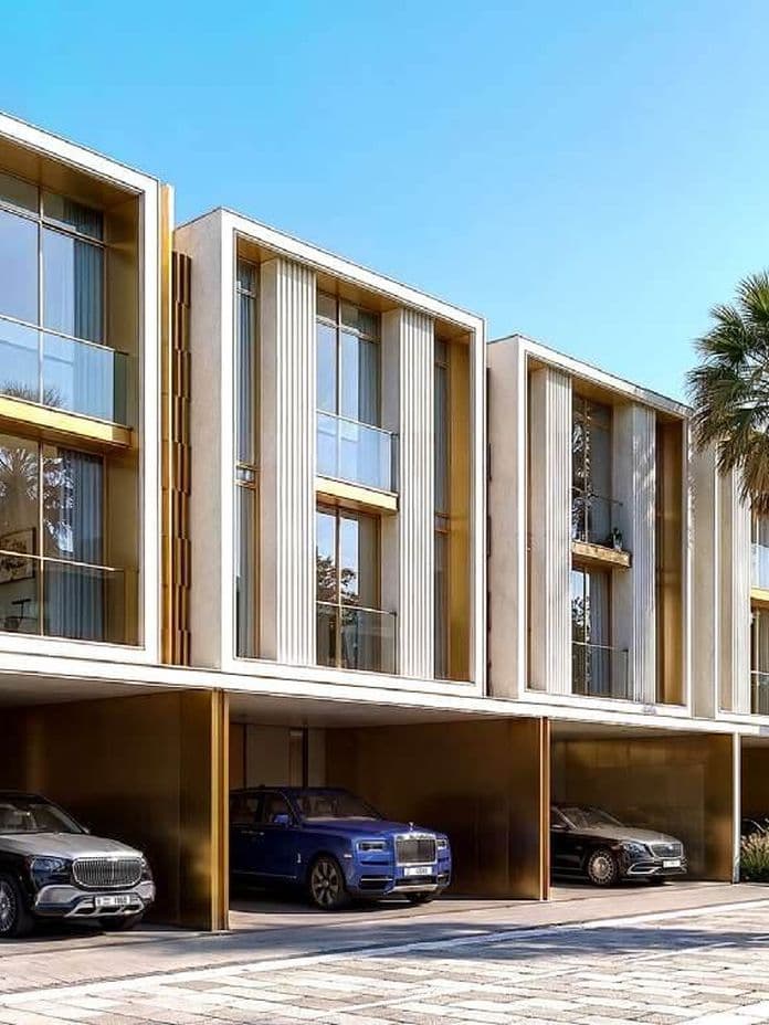 Modern three-story row of homes with large glass windows, palm trees, and luxury cars parked in the driveways on a sunny day.