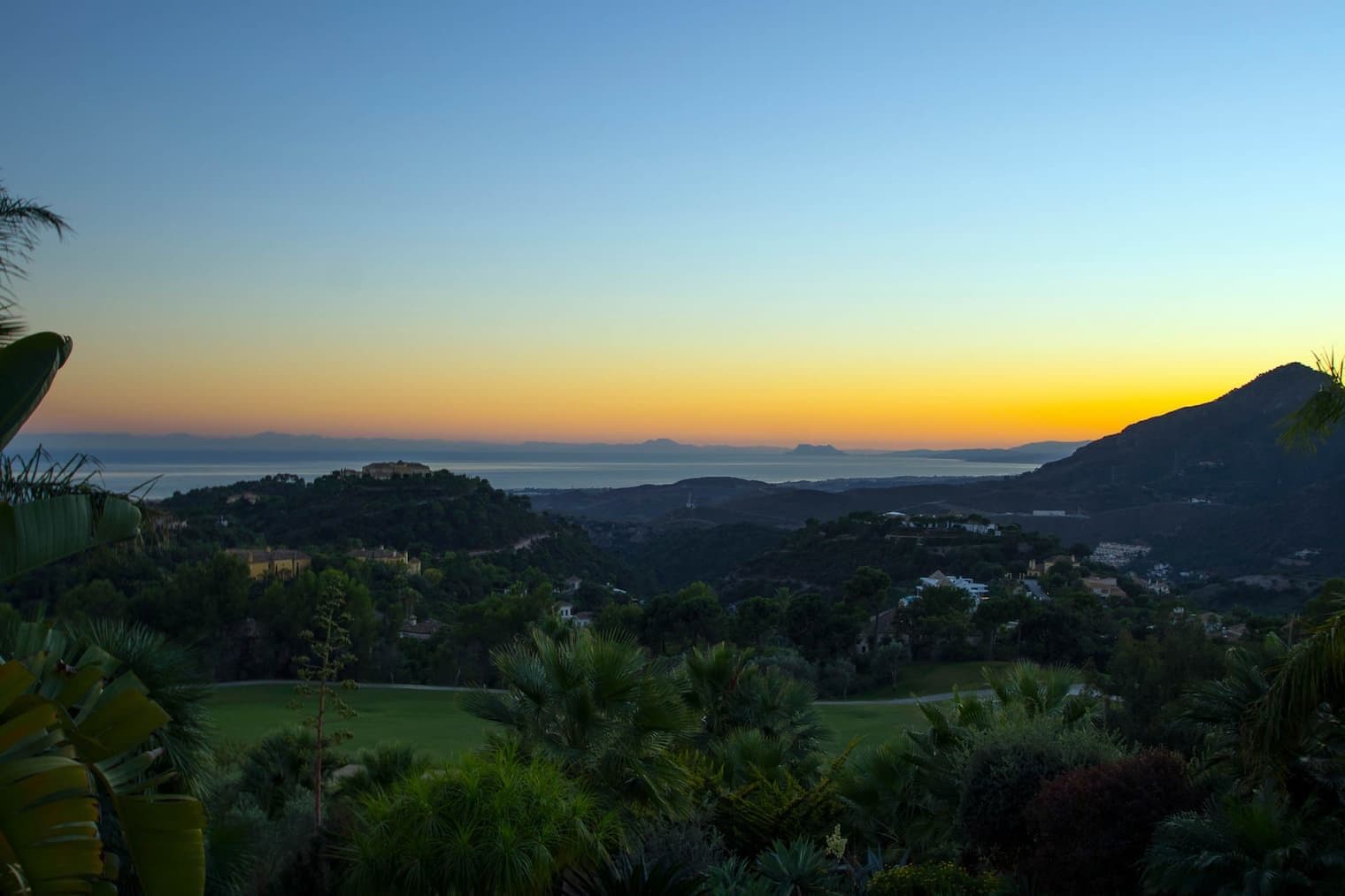 Vistes de La Zagaleta a la posta de sol amb el camp de golf i les muntanyes.