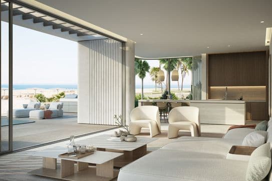 Modern beachfront living room with outdoor seating area and panoramic sea views.