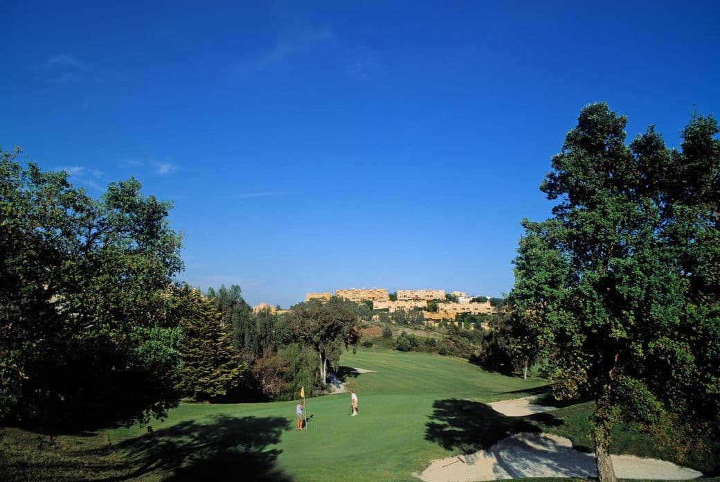 Campo de golf de La Quinta con apartamentos al fondo.