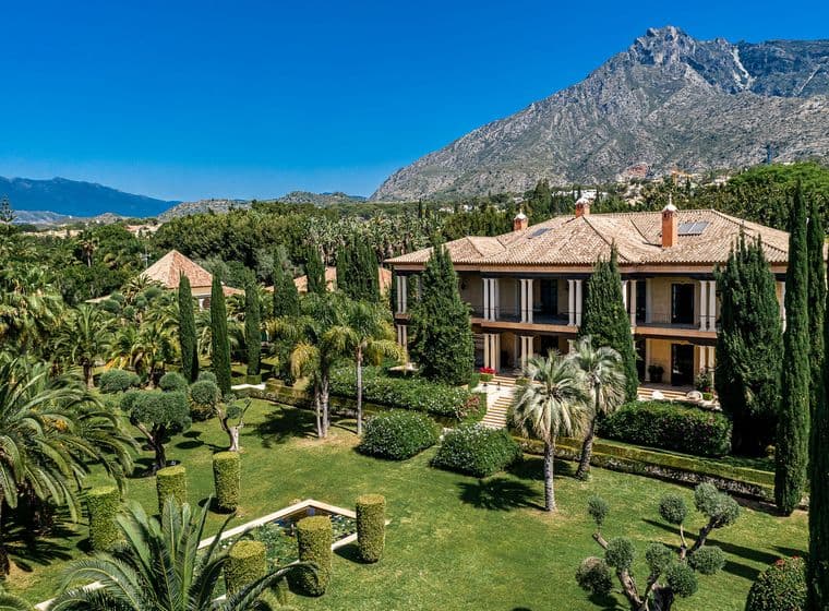 Vila de luxe a Nagüeles envoltada de fauna verda, davant de la muntanya La Concha de Marbella i amb un cel blau clar.