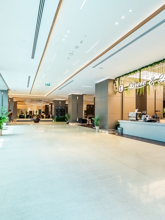 Sleek café corner named "Brew & Bliss" inside the Burj Nahar Building lobby, with modern lighting, plants, and a spacious lounge area.