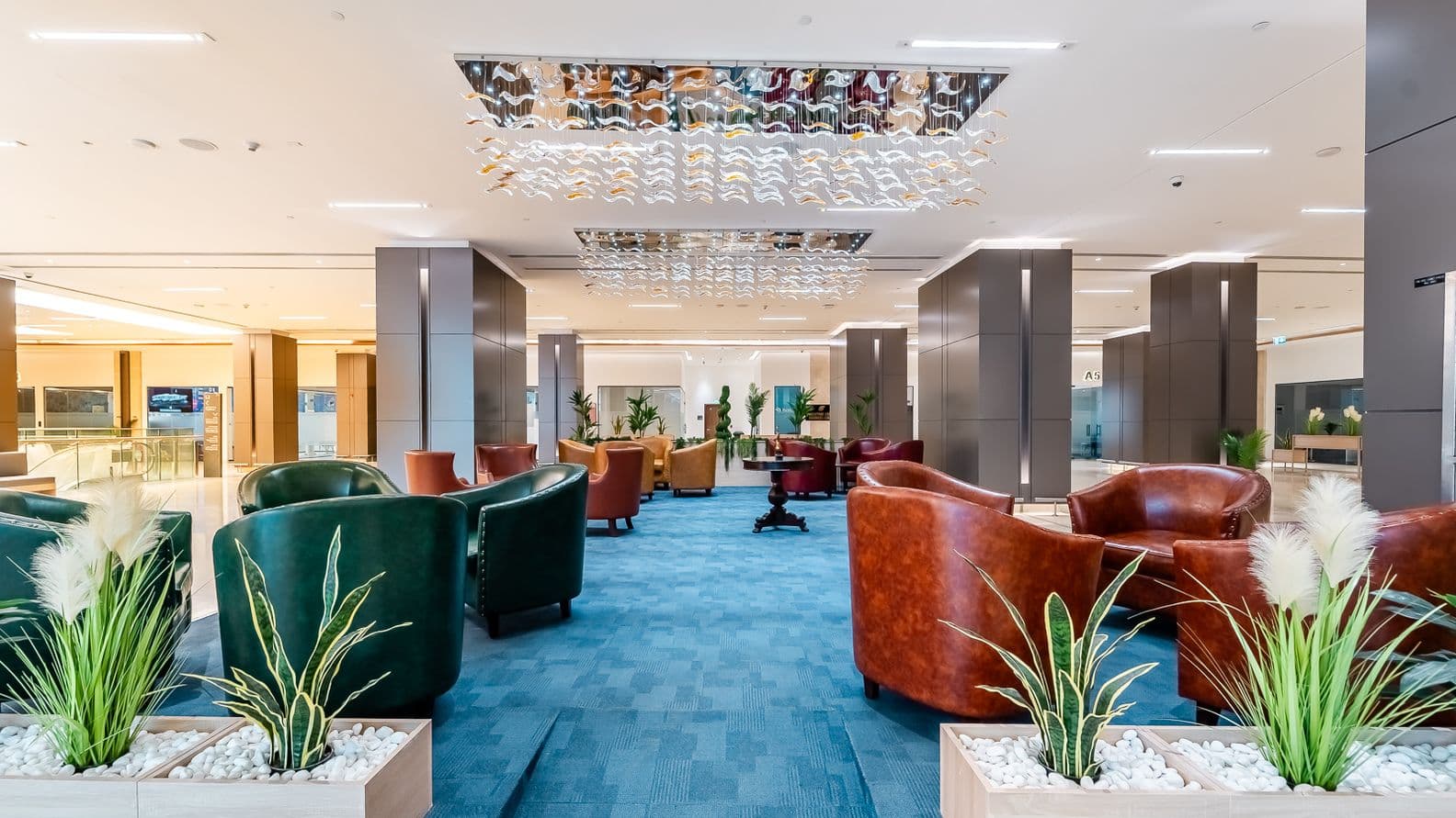 Spacious executive office in Burj Nahar Building with floor-to-ceiling windows, blue patterned carpet, and two workstations facing the city.