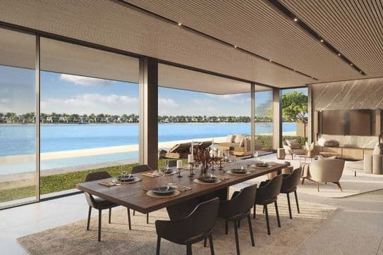 Modern dining and living area with large windows overlooking a serene lake and greenery. Wooden ceiling, elegant furniture, and neutral tones.