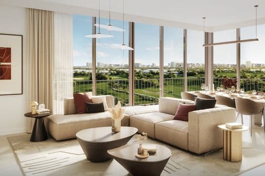 Modernes Wohnzimmer mit beigen Sofas, runden Tischen und großen Fenstern mit Blick auf eine grüne Landschaft. Essbereich mit gedecktem Tisch im Hintergrund.