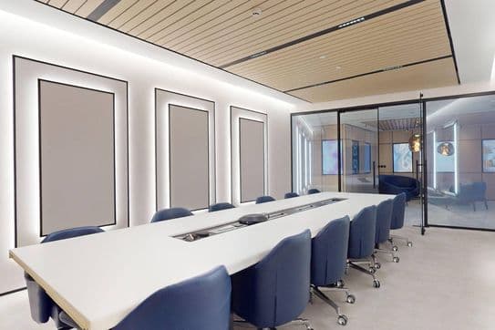 Sleek conference room with a long white table, navy blue chairs on casters, and glass walls opening to adjacent meeting spaces.