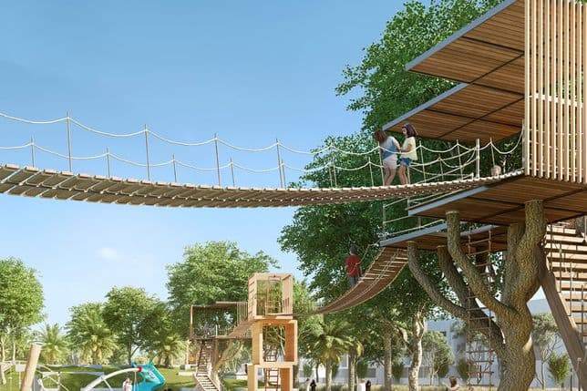 Families enjoy a modern treehouse structure at The Valley's adventure park, complete with rope bridges, elevated platforms, and children playing on climbing frames and slides.
