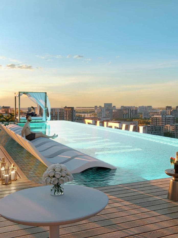 Infinity-Pool auf dem Dach bei Cove Edition 6 von Imtiaz Developers – mit Sonnenliegen, einer schattigen Cabana und weitem Blick über die Stadt.