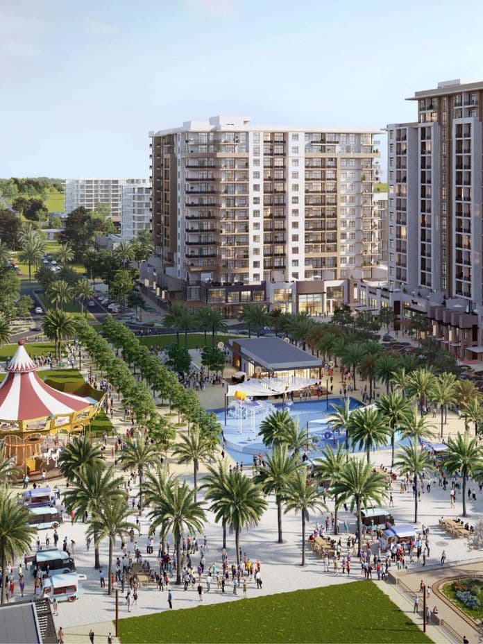 Lebendiger Gemeinschaftsplatz in Town Square mit den Camden-Residenzen, üppigen, von Palmen gesäumten Wegen, einem Karussell, Splash-Park, Foodtrucks und Familien, die gemeinsame Zeit im Freien genießen