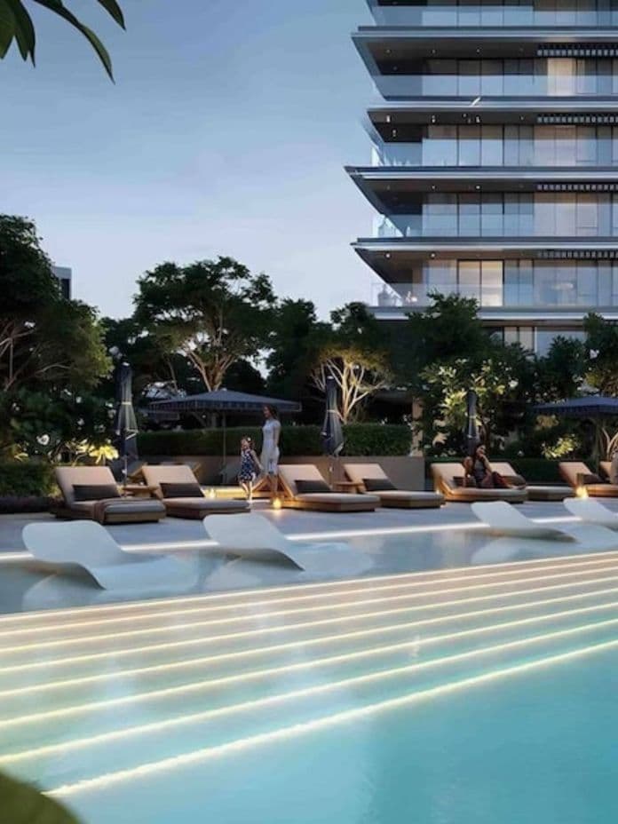 Illuminated outdoor pool and sunbeds at Rosehill Dubai Hills Estate by EMAAR, offering resort-style relaxation in a landscaped setting.