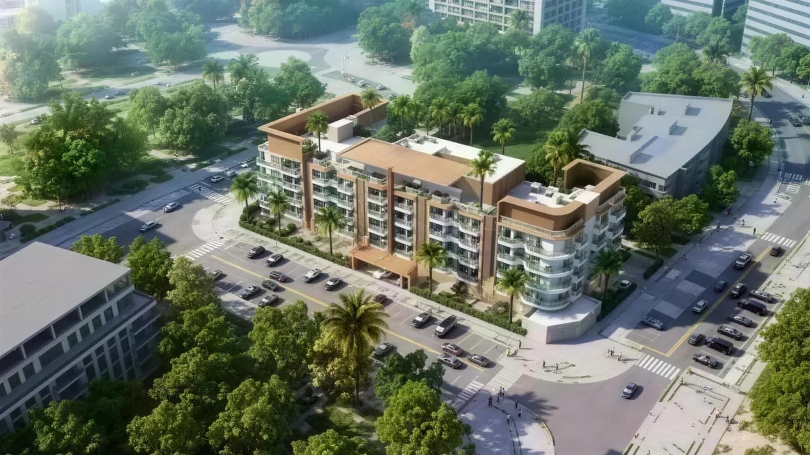 Aerial view of a modern, brown-and-white apartment complex with curved balconies, surrounded by palm trees, streets, and a green park.