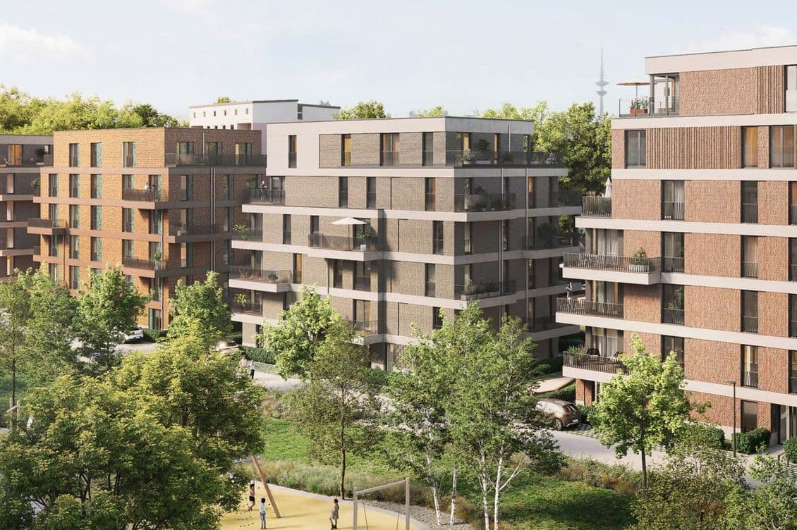 Modern apartment buildings with balconies, surrounded by trees and a park area with a playground, on a sunny day.