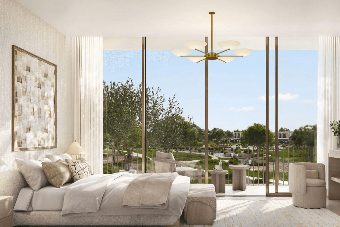 Ein helles Schlafzimmer in Vindera at The Valley mit raumhohen Fenstern und Blick auf gestaltete Gaerten und gruene Gemeinschaftsbereiche.