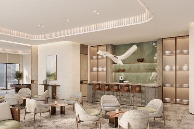 legant lounge area at Marriott Residences JLT with modern seating, bar counter, decorative shelving, and warm neutral interiors.