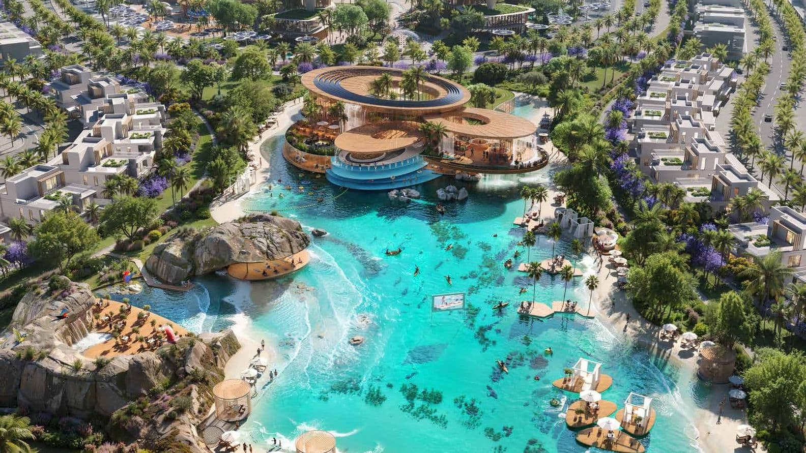 Aerial view of a luxurious resort with turquoise lagoon, sandy beaches, modern architecture, and surrounding greenery and palm trees.