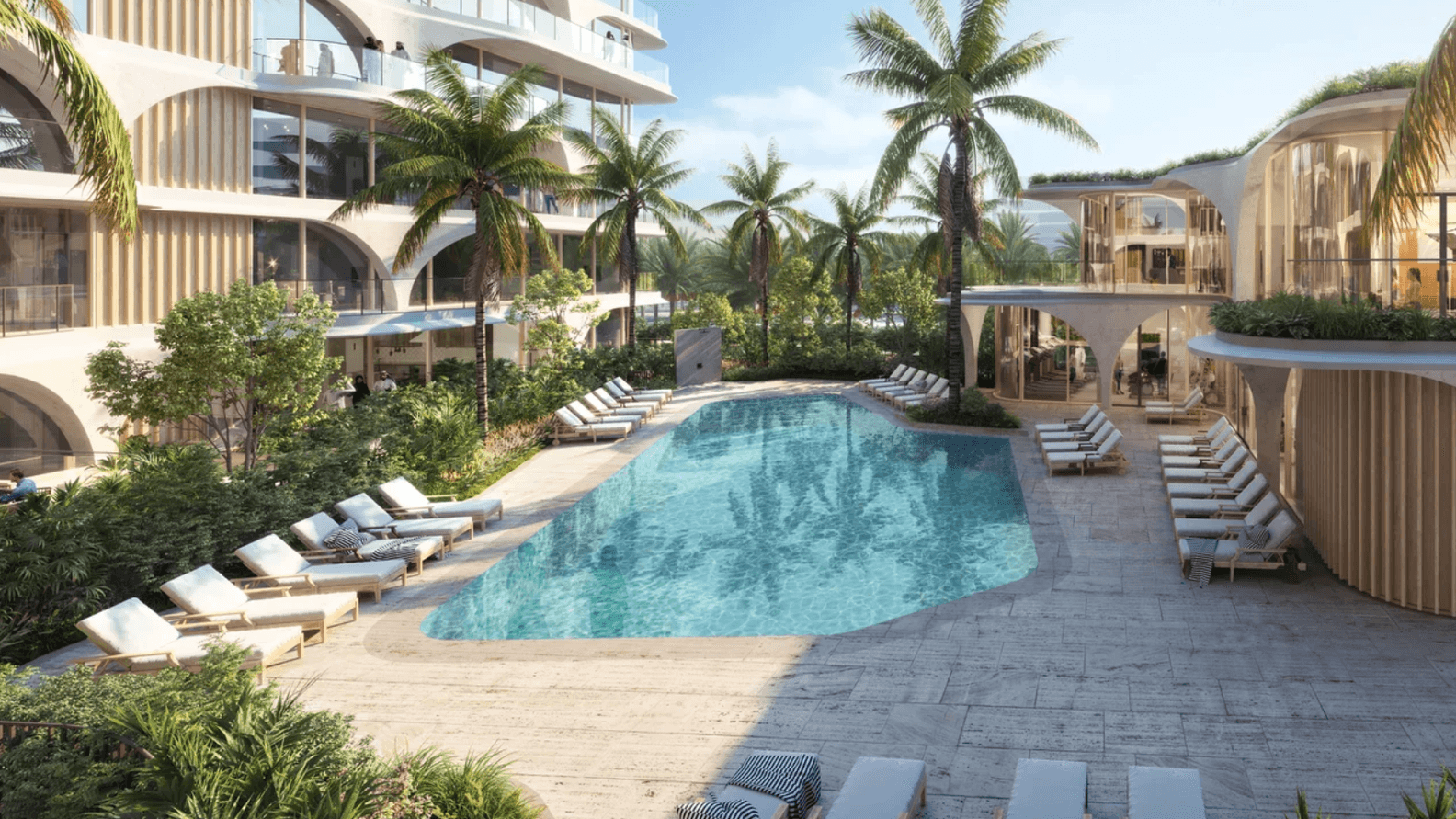 Modern resort pool area with palm trees, surrounded by lounge chairs and contemporary buildings, under a clear blue sky.
