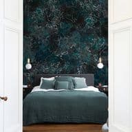 Bedroom view through open white doors. A green bed with pillows sits against a dark marble-patterned wall with hanging lights.