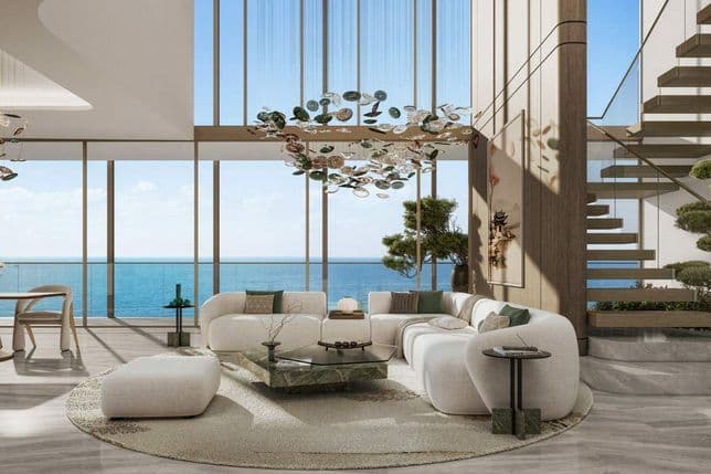 Modern living room with ocean view, large windows, contemporary furniture, artistic chandeliers, and a floating staircase, bathed in natural light.
