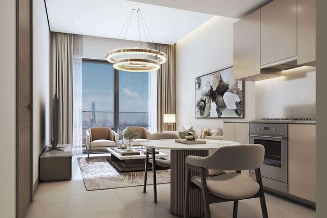Modern apartment living room with beige tones, featuring a round table, cozy seating, large window, and sleek kitchenette.