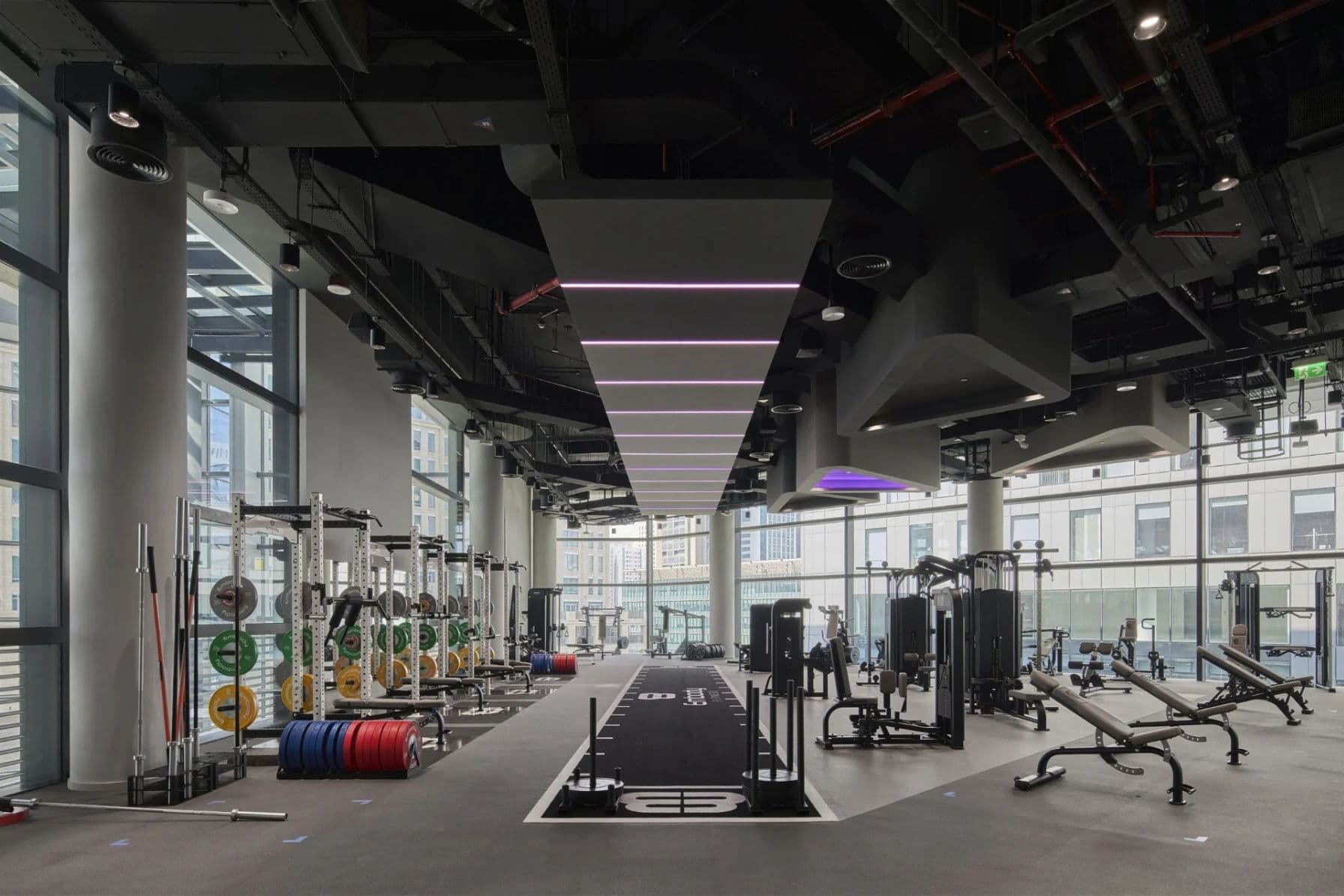 Large open gym floor with top of the range equipment amidst a city backdrop
