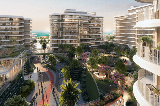 Modern apartment complex with curved balconies, lush gardens, and a walkway. People stroll below, with the sea visible in the background.