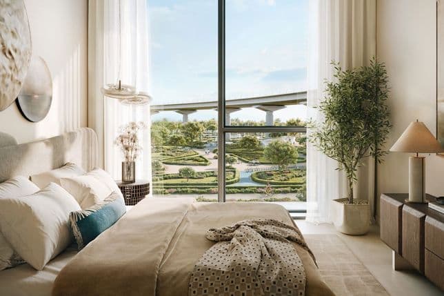 Bright interior with large window overlooking lush gardens, walking paths, and elevated transport route.