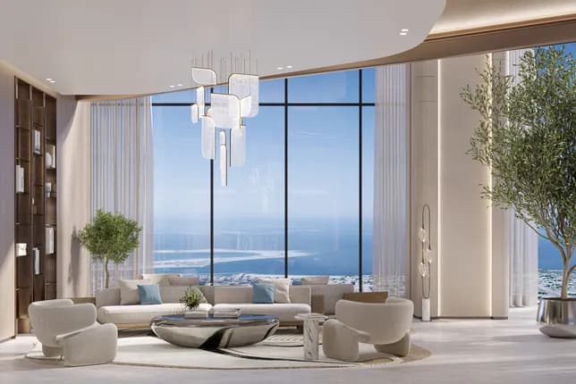 Luxurious living room with panoramic ocean view through floor-to-ceiling windows, featuring a beige sofa, circular rug, and glass chandelier.
