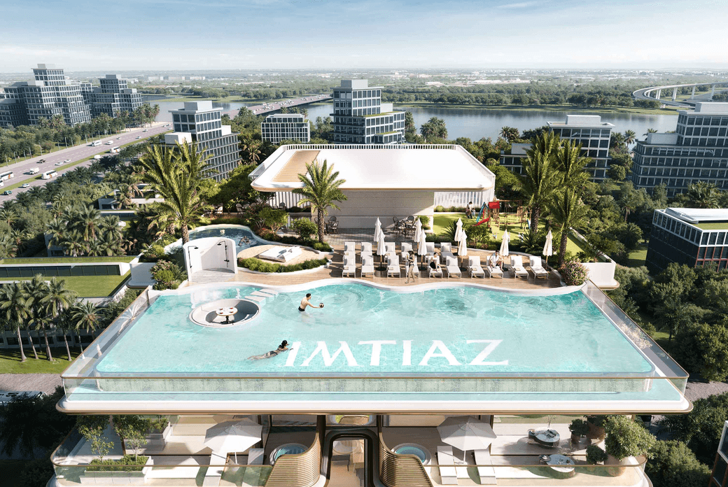 Rooftop amenities at Sunset Bay 5 featuring an infinity pool, sun loungers, landscaped seating areas, and elevated views over the surrounding community.