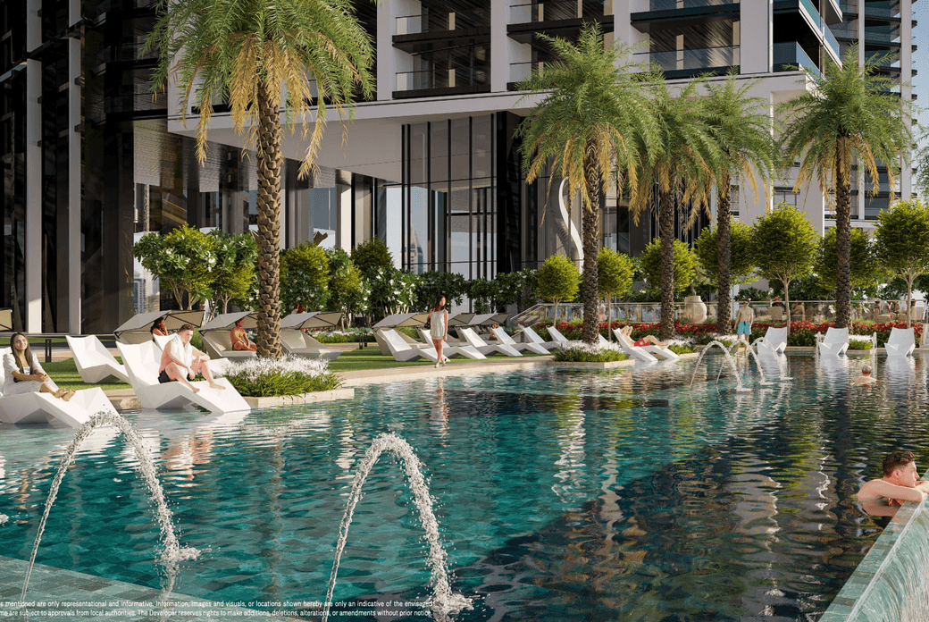 Modern outdoor pool area with palm trees, lounge chairs, and fountains. People relax by the water, surrounded by lush greenery and tall buildings.