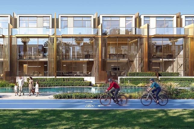 Modern glass-fronted townhouses with a garden, pool, and bike path. A family walks by the pool as cyclists ride on the path.