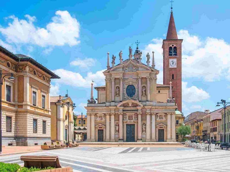 chiesa barocca con campanile in mattoncini rossi, in piazza assolata