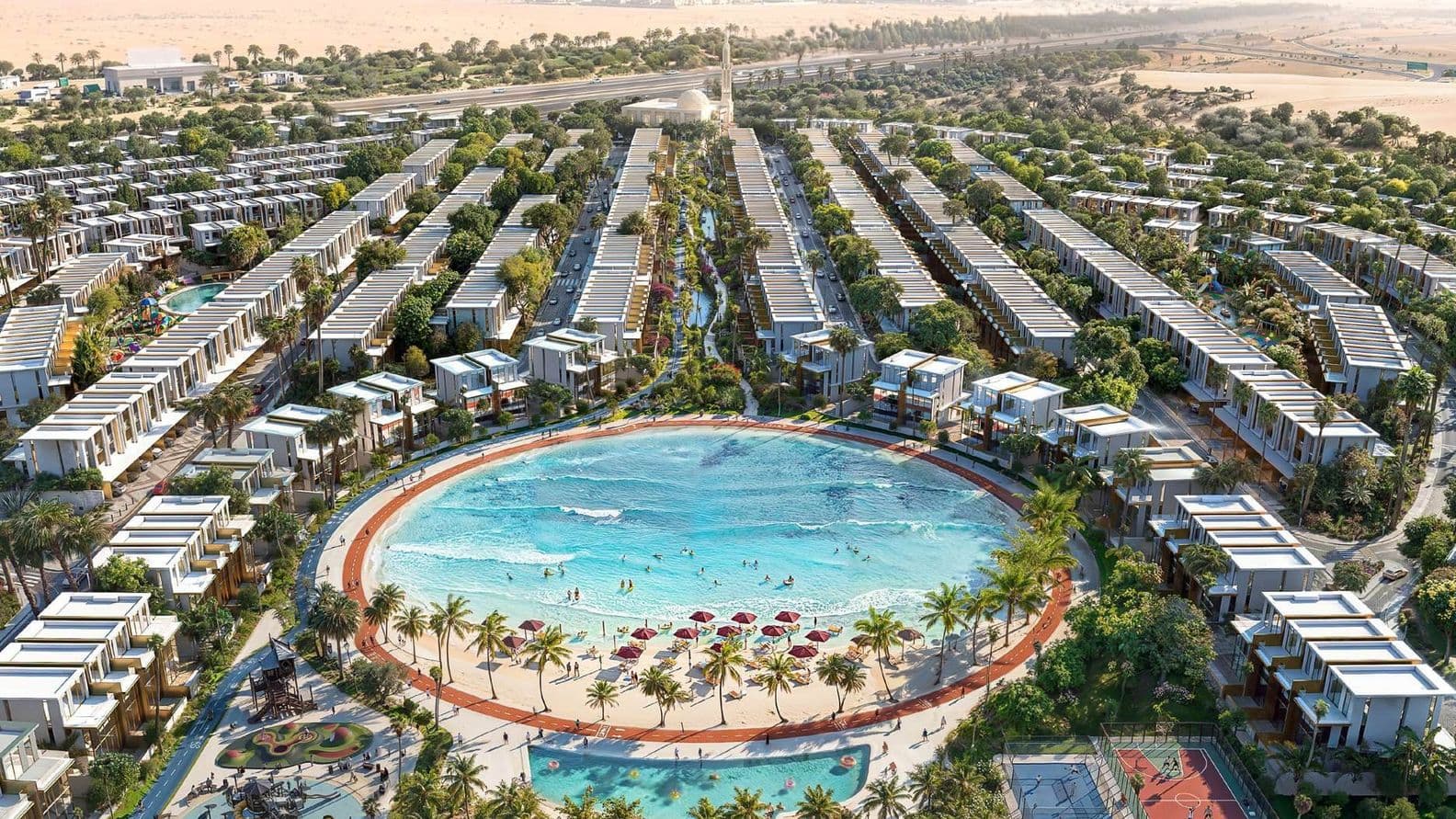 Aerial view of a luxury residential development with a large circular pool, sandy beach, palm trees, playground, and sports courts surrounded by villas.