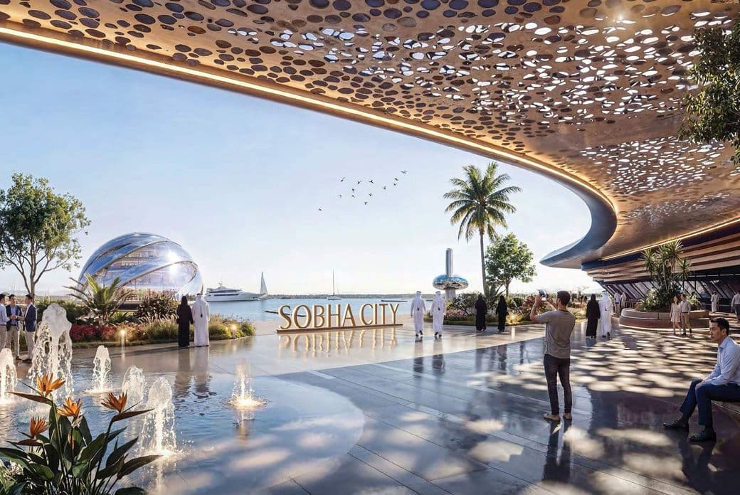Futuristic waterfront scene at Sobha City with people, modern architecture, fountains, and a view of the sea with yachts and a glass dome.