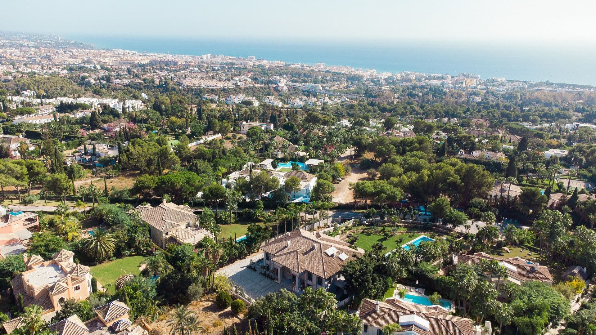 Aerial view of Sierra Blanca with many properties and the blue sea in the background.