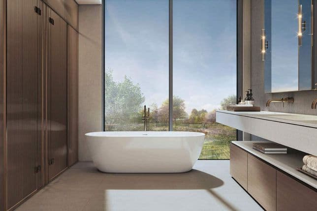 Modern bathroom featuring a freestanding tub, large window with scenic view, wooden cabinetry, and a sleek countertop with decorative items.