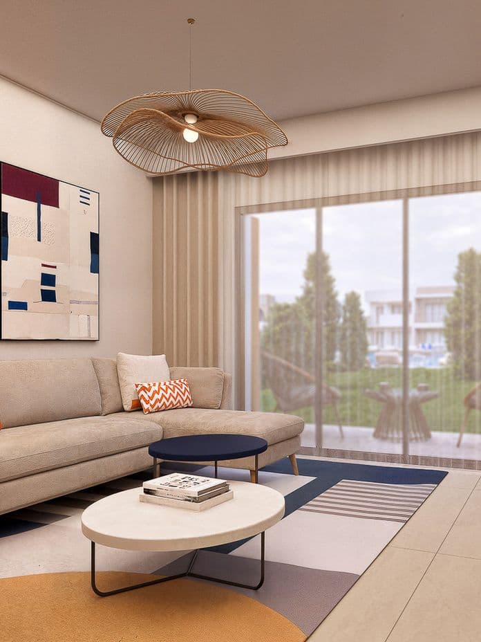 Modern living room with abstract art, beige sofa, round coffee tables, and a large window overlooking a garden. Neutral tones and contemporary decor.