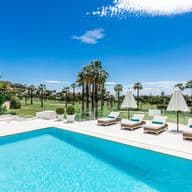 Clear swimming next to a green golf course and blue sky