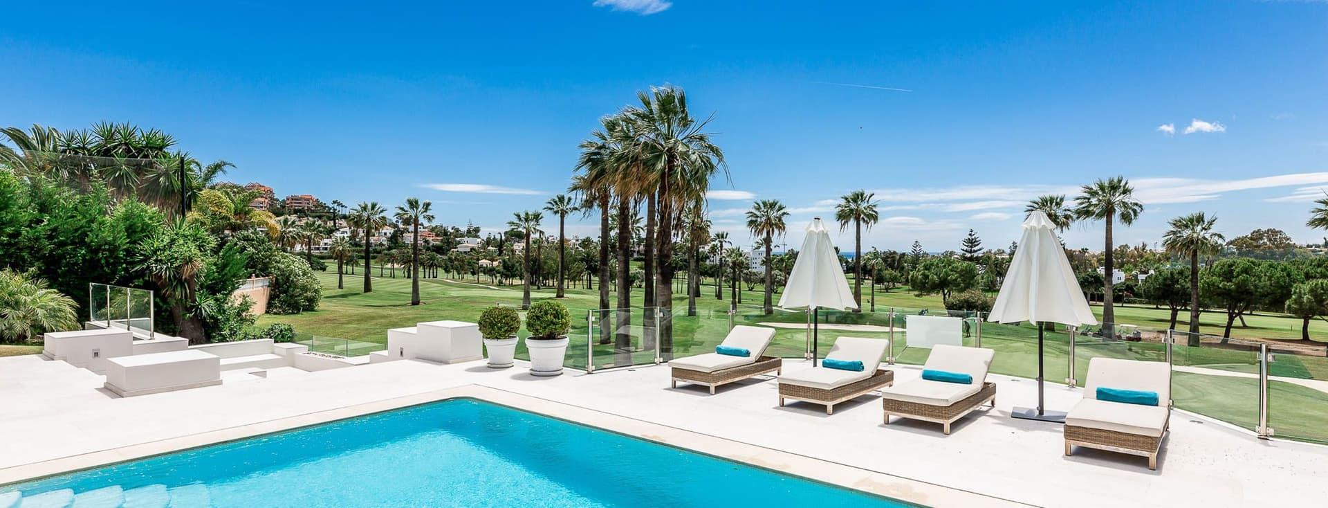 Clear swimming next to a green golf course and blue sky