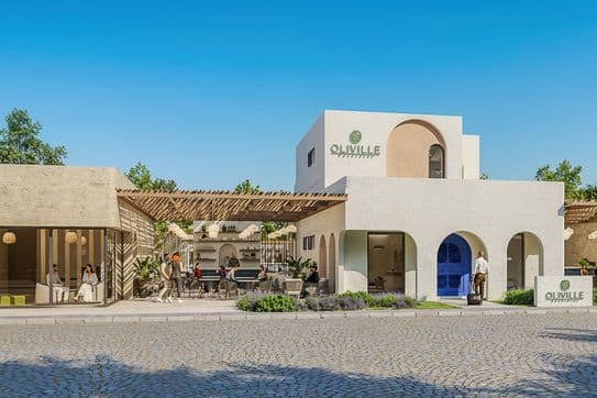 Modern Mediterranean-style building with white arches, wooden pergola, outdoor seating, and a sign reading "Oliville," under a clear blue sky.