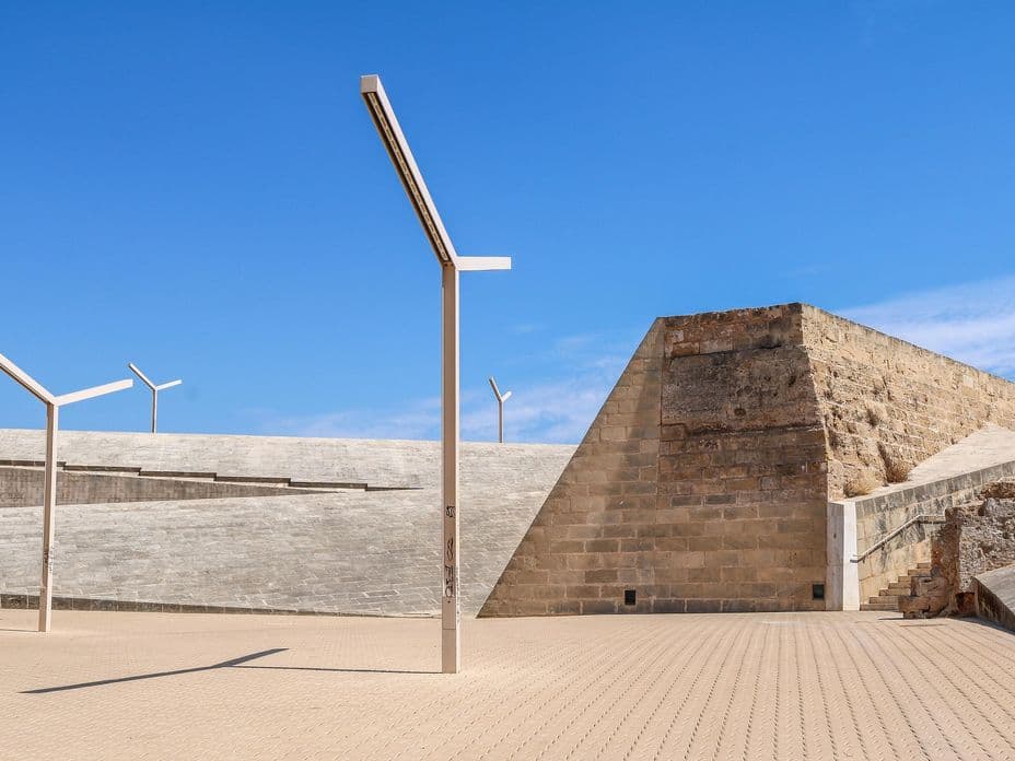 Vista exterior de l'Es Baluard Museu d'Art Contemporani de Palma a Mallorca, un impressionant museu d'art contemporani integrat a les històriques muralles renaixentistes de la ciutat. La imatge destaca la fusió de les antigues fortificacions de pedra amb elements arquitectònics moderns, com passarel·les de vidre, estructures minimalistes de formigó i terrasses obertes.