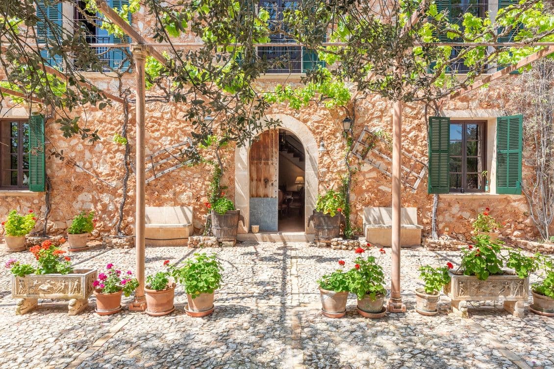 Beautiful natural stone façade of a traditional Mallorcan home in Porreres, showcasing rustic charm and warm Mediterranean character