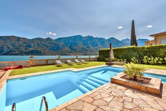 Privater Swimmingpool im Garten mit Liegestühlen und Blick auf den Comer See