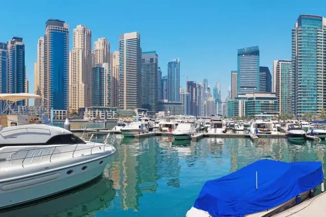 A sleek yacht docked with Dubai Marina skyscrapers in the background—perfect for showcasing professional yacht tours departing near Maritime City