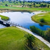 Luftaufnahme eines Golfplatzes in Torrevieja. Ein See und verschiedene Teile des Golfplatzes mit Bäumen sind zu sehen.